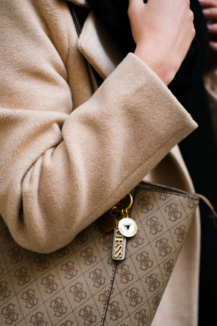 Sophisticated close-up of a stylish coat and designer handbag, showcasing elegance.