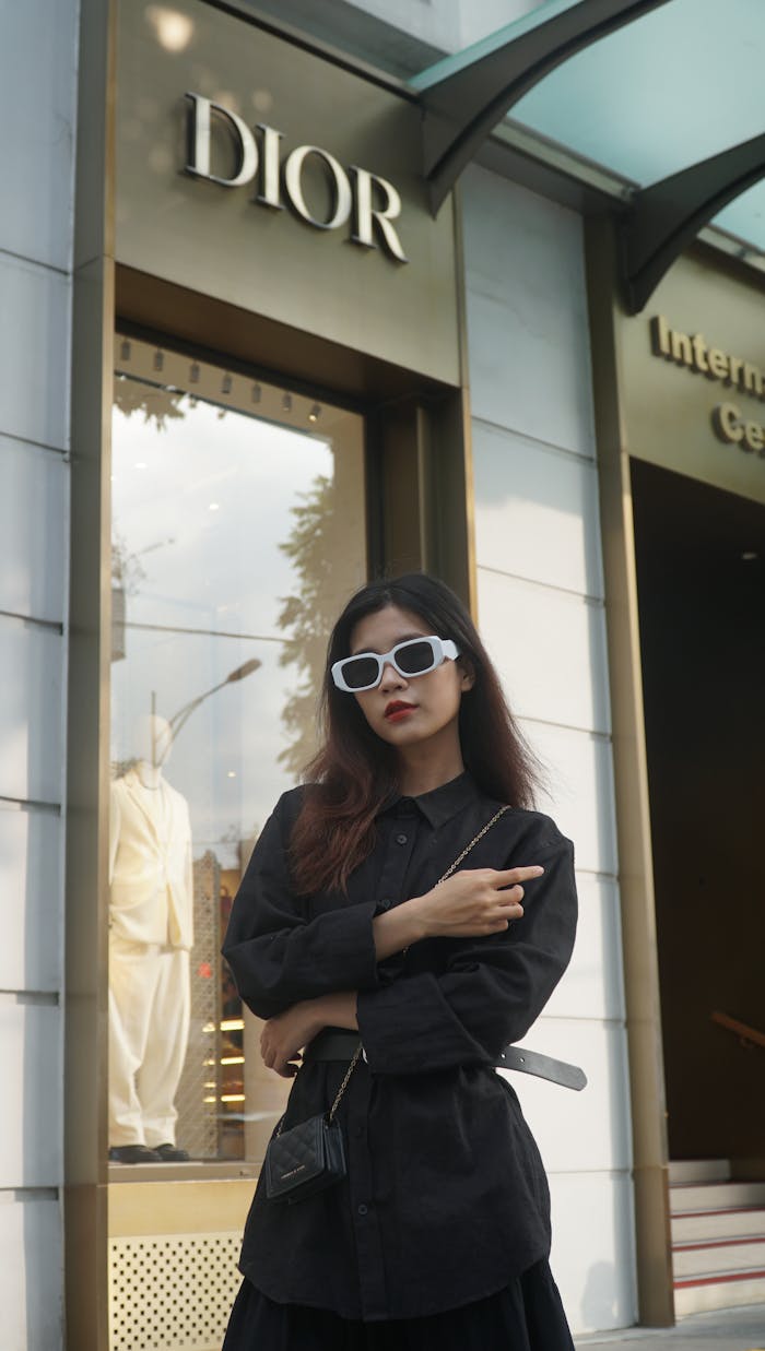 The Art of Drawing Readers In: Your attractive post title goes here Fashionable woman with sunglasses posing stylishly outside a Dior store.