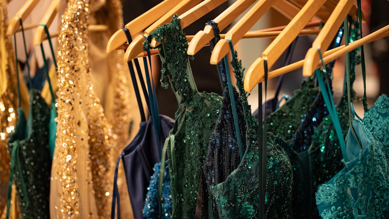 Sequin and lace evening gowns showcased at a Milan fashion event.