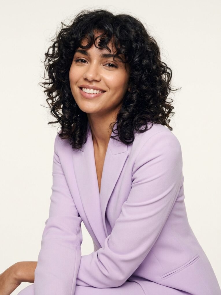 smiling woman with voluminous curls 202607221731